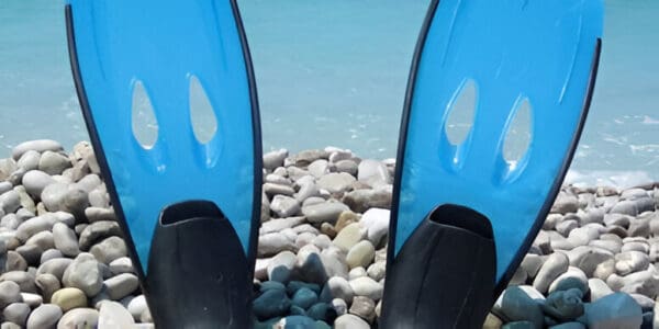 A pair of blue surfboards sitting on top of rocks.